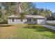 Gray house with white trim, white garage door, and green lawn at 9554 Bahia Rd, Ocala, FL 34472