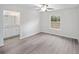 Spacious bedroom with ceiling fan and vinyl flooring, adjacent to bathroom at 175 Fisher Way Trl, Ocklawaha, FL 32179