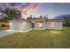 House exterior at dusk showcasing a teal front door and landscaping at 175 Fisher Way Trl, Ocklawaha, FL 32179