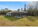 Home exterior showcasing a screened pool area at 6138 Sw 121St Ter, Ocala, FL 34481