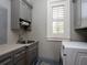 Convenient laundry room with gray cabinets and a window at 12757 Se 143Rd Ave, Ocklawaha, FL 32179