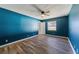 Spacious bedroom with teal walls, wood-look floors, and ceiling fan at 3720 Ne 28Th Ter, Ocala, FL 34479