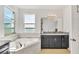 Bathroom with corner soaking tub, granite countertops, and large window at 455 Blue Cypress Dr, Groveland, FL 34736