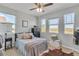 Bright bedroom with large windows, a comfortable bed, and ample natural light at 455 Blue Cypress Dr, Groveland, FL 34736