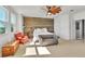 Bright bedroom with a large bed, accent chair, and wood-paneled wall at 455 Blue Cypress Dr, Groveland, FL 34736