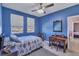 Blue bedroom with double bed, desk, and view at 455 Blue Cypress Dr, Groveland, FL 34736