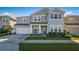 Two-story house with light blue exterior, white garage door, and landscaped front yard at 455 Blue Cypress Dr, Groveland, FL 34736