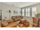 Living room with leather furniture, large windows, and a cozy atmosphere at 455 Blue Cypress Dr, Groveland, FL 34736