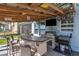 Covered outdoor kitchen with grill and bar seating at 455 Blue Cypress Dr, Groveland, FL 34736