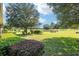 Landscaped backyard with golf course view and mature trees at 8470 Sw 82Nd Cir, Ocala, FL 34481