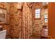 Elegant powder room with ornate wallpaper and brick floor at 1150 Sw 43Rd Pl, Ocala, FL 34471