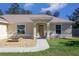 House exterior featuring a light beige color scheme, arched entryway, and well-maintained lawn at 17023 Sw 41St Avenue Rd, Ocala, FL 34473