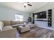 Living area with an L-shaped sofa, ottoman, large TV, and built-in shelving at 17023 Sw 41St Avenue Rd, Ocala, FL 34473