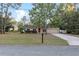 Tan one-story house with red door, attached garage, and landscaping at 20390 Sw 57Th St, Dunnellon, FL 34431