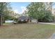 Tan one-story house with red door, attached garage, and landscaping at 20390 Sw 57Th St, Dunnellon, FL 34431