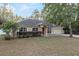 Tan one-story house with red door, attached garage, and landscaping at 20390 Sw 57Th St, Dunnellon, FL 34431