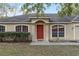 Front view of a tan house with red door and arched entryway at 20390 Sw 57Th St, Dunnellon, FL 34431