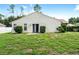 House exterior showcasing backyard with lush grass and shrubs at 21174 Sw Peach Blossom St, Dunnellon, FL 34431