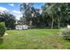 Large backyard with grassy area and a storage shed at 21174 Sw Peach Blossom St, Dunnellon, FL 34431