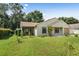 House with a screened porch, mature trees, and a spacious lawn at 21174 Sw Peach Blossom St, Dunnellon, FL 34431