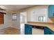 Bright kitchen with teal cabinets and pass-through to dining area at 21174 Sw Peach Blossom St, Dunnellon, FL 34431