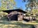 Dark brown cabin exterior with wooden deck and surrounding trees at 45202 Nfs Rd 572-B, Altoona, FL 32702