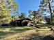 Dark brown cabin with a deck nestled in a wooded area at 45202 Nfs Rd 572-B, Altoona, FL 32702