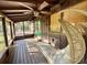 Bright screened porch with hanging chair and wooden flooring at 45202 Nfs Rd 572-B, Altoona, FL 32702