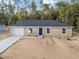 Tan house with gray roof, white garage door, and blue front door at 15385 Sw 29 St, Ocala, FL 34481