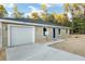 Tan house with gray roof, white garage door, and blue front door at 15385 Sw 29 St, Ocala, FL 34481