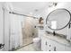 Modern bathroom with a walk-in shower, vanity, and round mirror at 2704 Se 31St St, Ocala, FL 34471