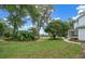 Landscaped front yard with mature trees and walkway leading to charming farmhouse at 2704 Se 31St St, Ocala, FL 34471