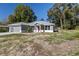 Newly built home with gray exterior, red door, and a spacious yard at 3325 Se 131St Pl, Belleview, FL 34420