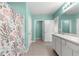 Main bathroom with double vanity, shower, and teal walls at 3853 Se 99Th Ln, Belleview, FL 34420