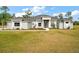 Two-story house with gray siding, a large front yard, and a three-car garage at 7403 Ne 22Nd Court Rd, Ocala, FL 34479