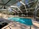 Inviting screened-in pool area with lounge chairs, ready for relaxation at 7535 Sw 185 Avenue Rd, Dunnellon, FL 34432