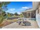 Spacious backyard patio features a round table and benches, overlooking the lawn at 10962 Sw 81St Ave, Ocala, FL 34481