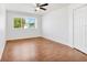 Bedroom with wood floors, large window, and ceiling fan at 10962 Sw 81St Ave, Ocala, FL 34481