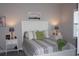 Bright bedroom with a white bed frame, patterned bedding, and nightstands at 13091 Sw 77Th Ct, Ocala, FL 34473