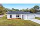 Single-story house with gray roof, two-car garage, and landscaping at 14897 Sw 27Th Ln, Ocala, FL 34481