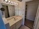 Bathroom boasts a vanity with sink, large mirror, and linen closet at 2444 Se 18Th Cir, Ocala, FL 34471