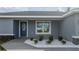 Front entrance of the home featuring a gray door and stone accents at 6 Dogwood Circle Pl, Ocala, FL 34472