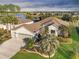 Aerial view of a single-Gathering home with a two-car garage, beautifully landscaped yard, and a lake view in the background at 6671 Sw 97Th Terrace Rd, Ocala, FL 34481