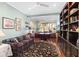 Bright home office features built-in shelving, a comfortable sofa, and a large desk at 6671 Sw 97Th Terrace Rd, Ocala, FL 34481