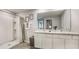 Double vanity bathroom with a shower and gray tile floor at 8469 Las Palmas Way, Wildwood, FL 34785