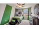 Bright bedroom with green accent wall and gaming decor at 8469 Las Palmas Way, Wildwood, FL 34785