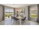 Dining room with white table, black chairs, and view of the backyard lake at 8469 Las Palmas Way, Wildwood, FL 34785