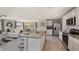 Open kitchen features granite island, stainless steel appliances, and view to Gathering room at 8469 Las Palmas Way, Wildwood, FL 34785