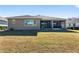 Back of house with screened porch and grassy yard at 9350 Sw 91St Court Rd, Ocala, FL 34481