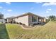 House back view showcasing a screened porch, landscaping, and partial view of the side yard at 9826 Sw 63Rd Loop, Ocala, FL 34481